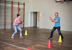Nauczyciele wychowania fizycznego grają w pilkę w sali gimnastycznej